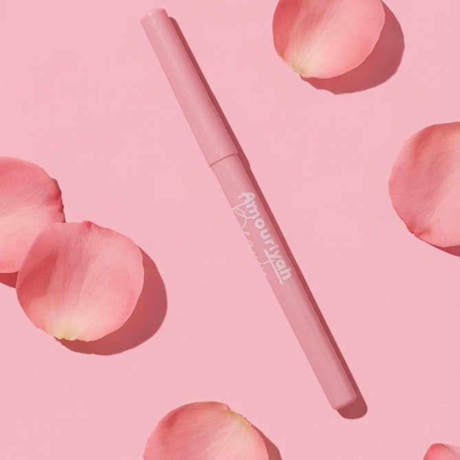 Pink eyeliner pencil on a pink background with rose petals